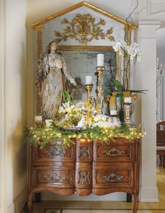 an ornate dresser with candles and flowers on it