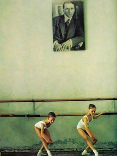 two young women are practicing ballet moves in front of a portrait