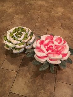 two fake flowers sitting on top of a tiled floor