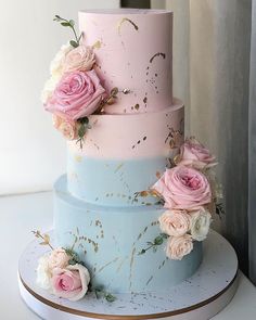 a three tiered cake with pink and blue frosting