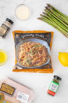 ingredients to make pasta on a marble countertop with lemons, garlic and seasonings