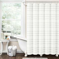 a bathroom with a tub, shower curtain and rug in front of the bathtub