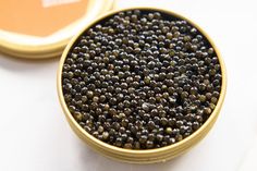 a bowl filled with black seed next to a container