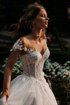 a woman in a wedding dress standing outside