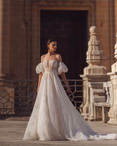 a woman in a wedding dress is standing outside