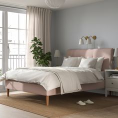 a bedroom with a pink bed and white sheets