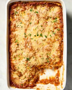 lasagna casserole with cheese and parsley in a white baking dish