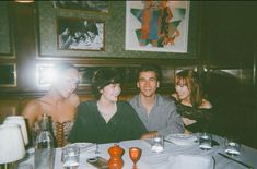 three people sitting at a table in a restaurant