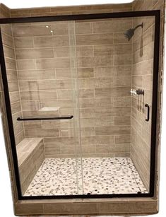 a walk in shower sitting next to a tiled wall