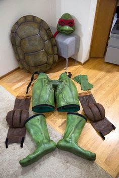 a turtle costume laying on the floor next to a tortoise shell