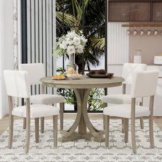 a dining room table with white chairs and a potted plant in the center on top of it