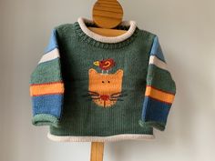 a green sweater with an orange cat on it