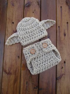 a crocheted hat and diaper cover sitting on top of a wooden floor