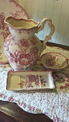 a table topped with plates and a vase on top of a doily covered table