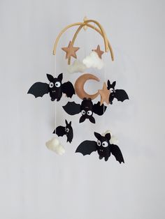 a mobile with bats and stars hanging from it's sides on a white wall