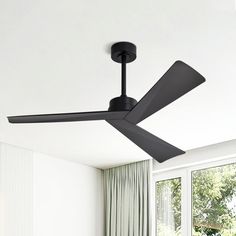 a black ceiling fan in a white room