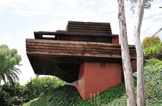 an unusual house built into the side of a hill with grass growing on it's sides