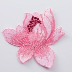 a pink flower is shown on a white surface