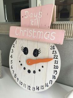 a wooden snowman clock sitting on top of a table