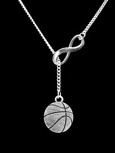 a silver necklace with a basketball hanging from it's center chain on a black background