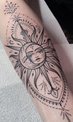 a sun and moon tattoo on the left arm, with an arrow in the middle