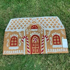 a gingerbread house door mat on the grass