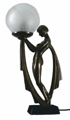 a lamp with a woman holding a white ball on it's arm and standing up