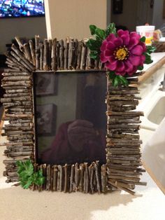 a photo frame made out of sticks and flowers