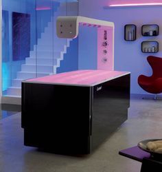 a pink and black desk in the middle of a room with stairs leading up to it