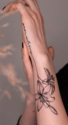 a woman's arm with a flower tattoo on the left side of her hand