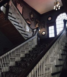 the stairs are made of wood and have white railings with mirrors on each side