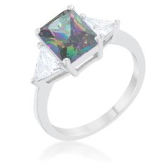 a white gold ring with an iridescent colored diamond in the center and two princess cut diamonds on each side