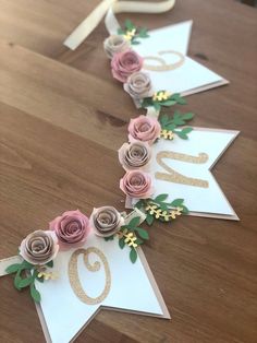 some paper flowers are laying on top of each other and the number twenty five is decorated with gold foil