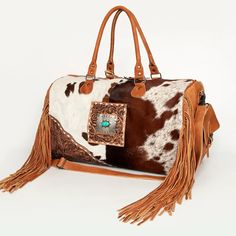 This American Darling hair-on cowhide genuine leather complements the bag with a soft touch as well as decorates it. YKK well known long lasting and heavy-duty zipper closures ensure security of your essentials.  The bag has an adjustable and detachable long shoulder strap. For detachment, stainless steel snap hooks are used because these are durable and easy to use. The short handle straps of this duffle makes it easier to carry with your hands whenever you want. American darling has designed this duffle that is all you need for a weekend, trip, sports or gym to carry a great deal of your belongings as it is a lot spacious and roomy. Its style would leave just the perfect mark of your grace on everyone around you wherever you go. A luxurious and western handcrafted leather duffel bag desi Western Handbags, Leather Duffel Bag, Leather Duffel, Tan Cowhide, Painting Leather, Timeless Accessories, Tooled Leather, Leather Fringe, Handcrafted Leather