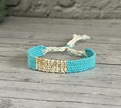 Handwoven bracelet in turquoise - gold - white Made from fine linen and Cotton (warp yarn). The bracelet is light and very comfortable to wear and can be wonderfully combined with other bracelets. Length of the woven band approx. 12.5 cm The size is suitable for every wrist circumference and is infinitely adjustable using a sliding knot. Material: Linen Cotton (warp yarn) Sliding knot made of nylon yarn Gold Woven Bracelets For Friendship, Adjustable Gold Handwoven Friendship Bracelets, White Woven Bracelet Jewelry, White Woven Jewelry Bracelet, Gold Woven Braided Bracelets For Beach, Gold Braided Bracelets For Beach, White Handwoven Adjustable Bracelets, Adjustable White Handwoven Bracelets, Sliding Knot