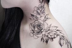 a woman's neck with flowers and leaves on her left side, behind her ear