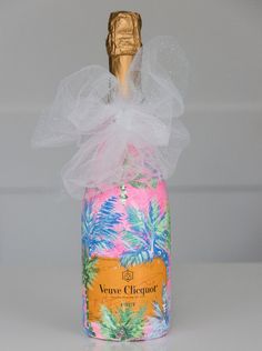 a bottle of wine with a bow on it's cap and ribbon around the top