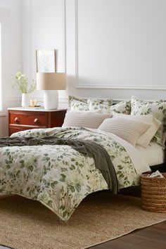 a bed with white and green comforters in a bedroom