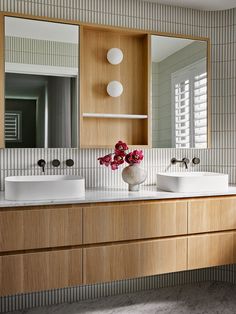 a bathroom with two sinks and a large mirror over it's counter top,