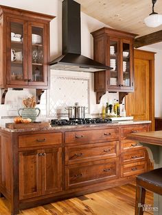 a kitchen with wooden cabinets and an island in the middle, along with a stove top oven