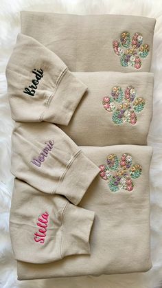 three personalized sweatshirts on top of a white blanket