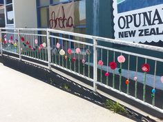 the fence is decorated with flowers and paper pom - poms, along with other decorations