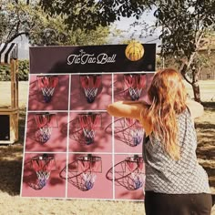 a woman standing in front of a sign with basketballs drawn on it's sides