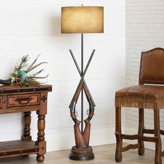 two wooden chairs sitting next to each other near a lamp