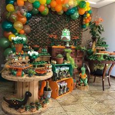 a room filled with lots of green and orange balloons