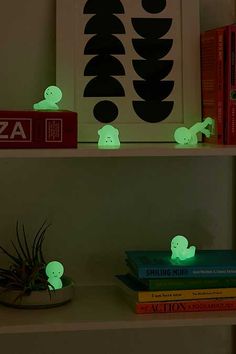 some books are sitting on a shelf with glowing lights in the shape of ghostes