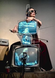 a man sitting on top of a television set