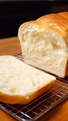 a loaf of bread sitting on top of a metal rack next to a slice of bread