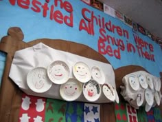 there are paper plates on the wall with children's drawings on them and in front of it