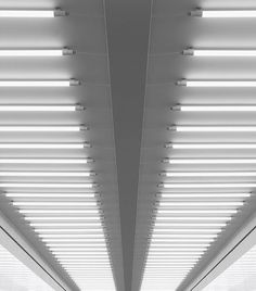 an empty hallway with white walls and ceiling lights